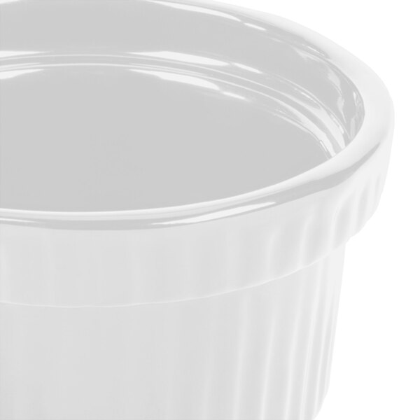A close-up of a white Tablecraft cast aluminum souffle bowl with ridges.