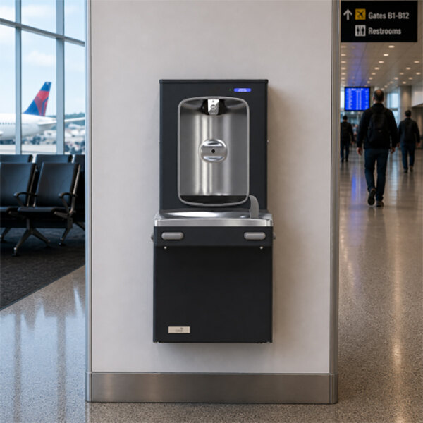 A wall-mounted drinking fountain with a bottle filler is installed in a public indoor space, such as an airport terminal.