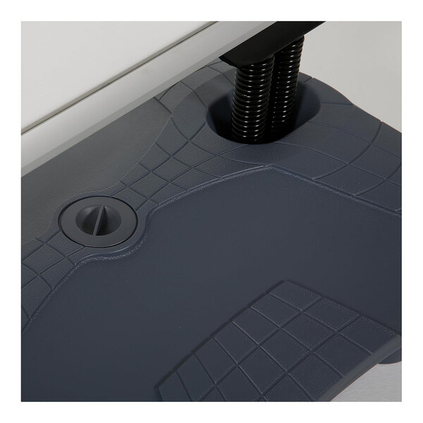 A close-up view of a textured gray plastic base with a circular cap and two black coiled tubes inserted into it.