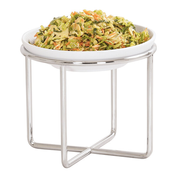 A white bowl filled with a mixed salad is placed on a chrome wire stand with a modern, geometric design.
