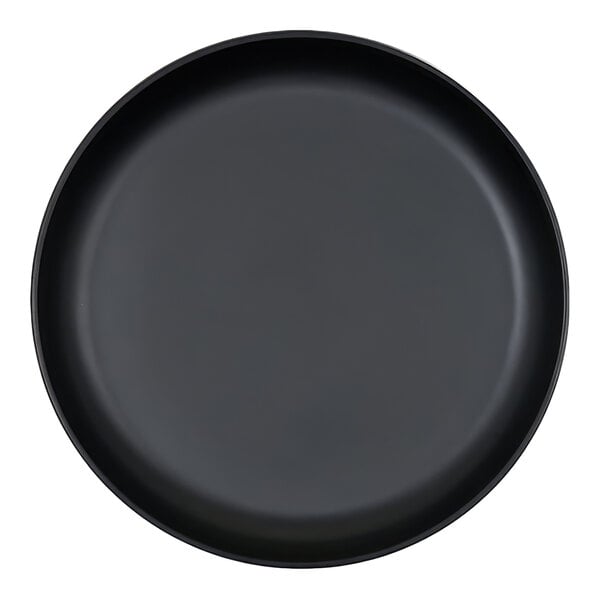 A black, round plate with a raised rim, viewed from above.