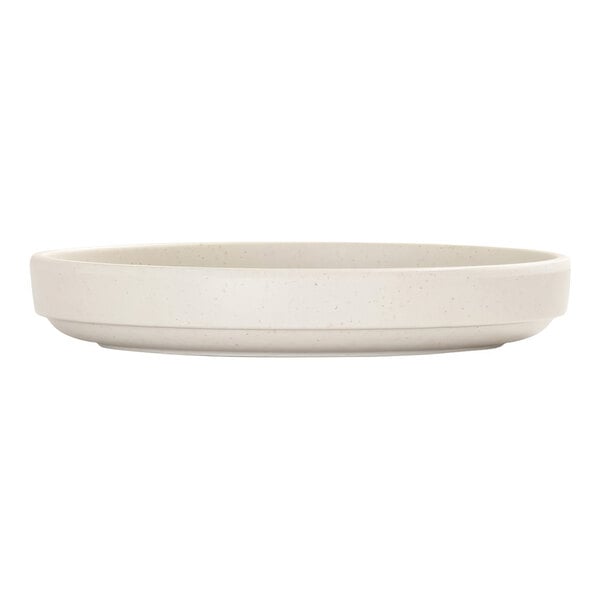 A round, ivory-colored plate with a raised rim and subtle speckled pattern, shown from the side.