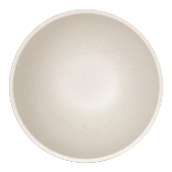 A top-down view of a plain, round, ivory-colored bowl with a subtle speckled pattern.