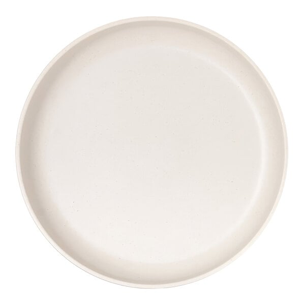 A round, ivory-colored plate with a raised rim and subtle speckled pattern.