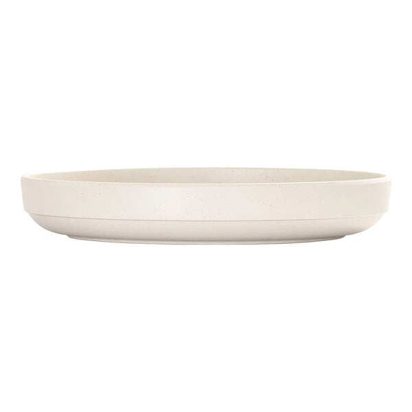 A round, ivory-colored plate with a raised rim and a subtle speckled pattern, shown from a side view.