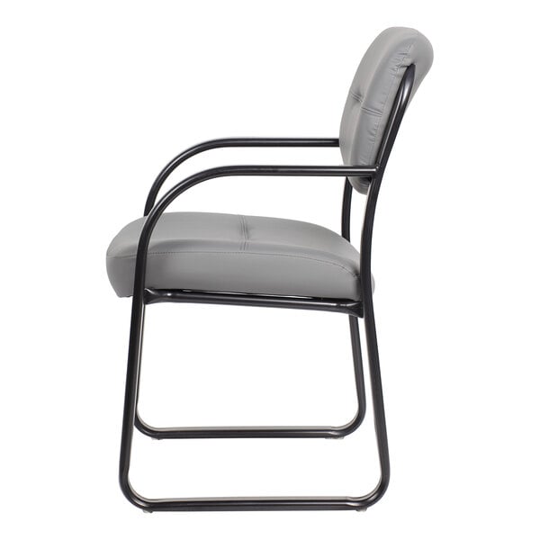 A side view of a gray cushioned chair with a black metal sled base and armrests.