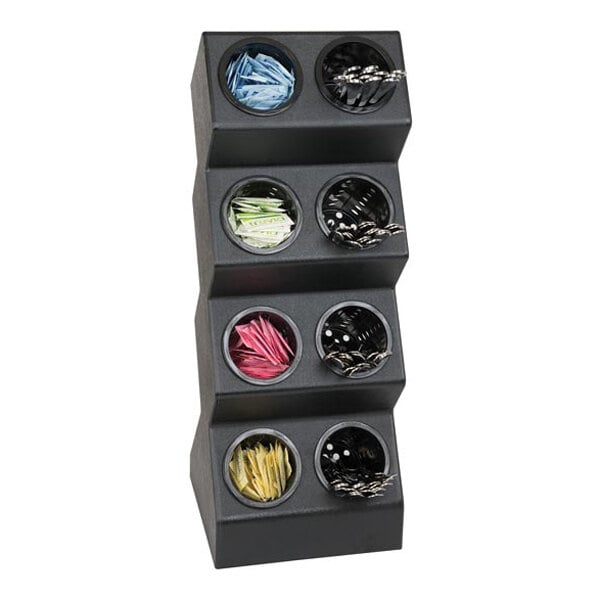 A black, multi-tiered countertop organizer with eight round compartments, each holding various colored packets and utensils.