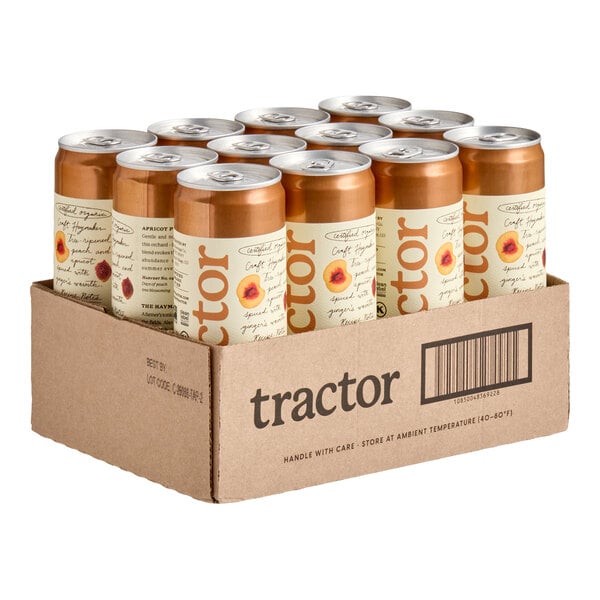 A cardboard case containing twelve cans with copper-colored tops and cream-colored labels featuring apricot and peach illustrations.