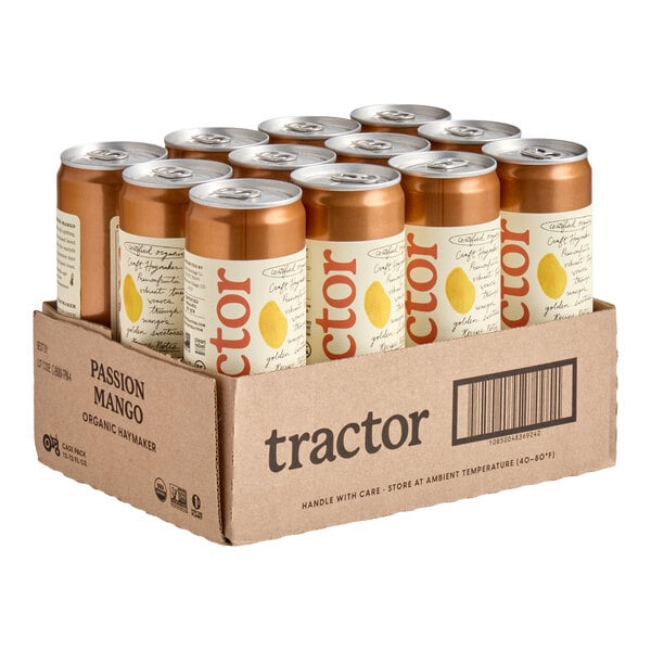 A cardboard case containing twelve orange and cream-colored cans with silver tops, labeled with the word 'tractor' and a yellow fruit graphic.
