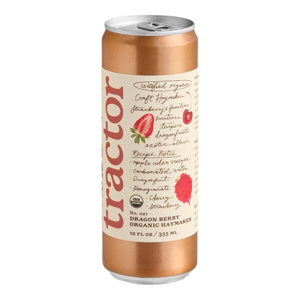 A tall, metallic can with a beige label featuring red text, illustrations of strawberries and a dragon fruit, and the word 'tractor' prominently displayed vertically.