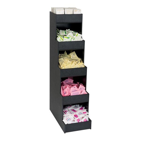 A black vertical organizer with five sections, each holding various packets such as sweeteners and creamers.