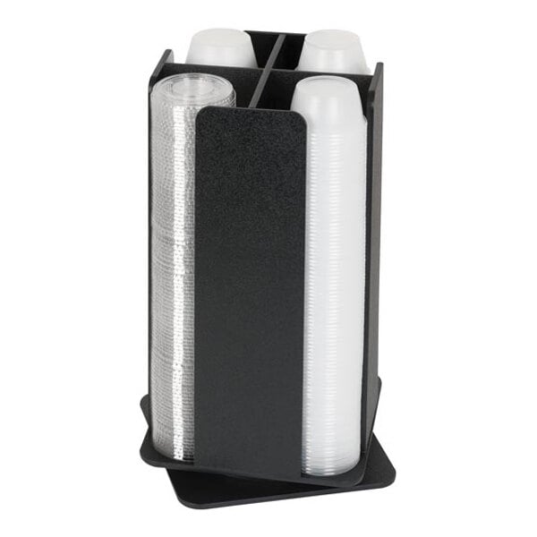 A black, four-section revolving countertop organizer holding stacks of clear and white plastic cups.