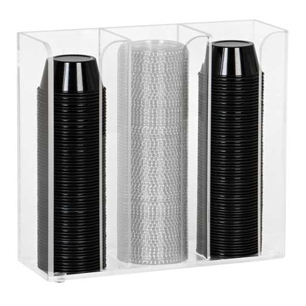 A clear acrylic organizer with three vertical sections holding stacks of black and clear plastic cups or lids.