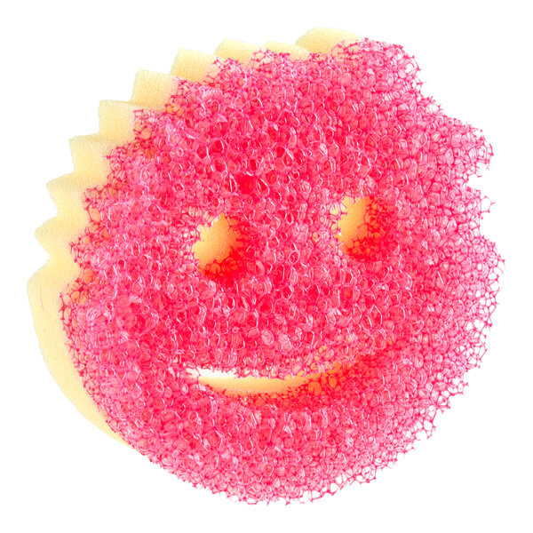 A round yellow and pink sponge with a smiley face design and textured surface.