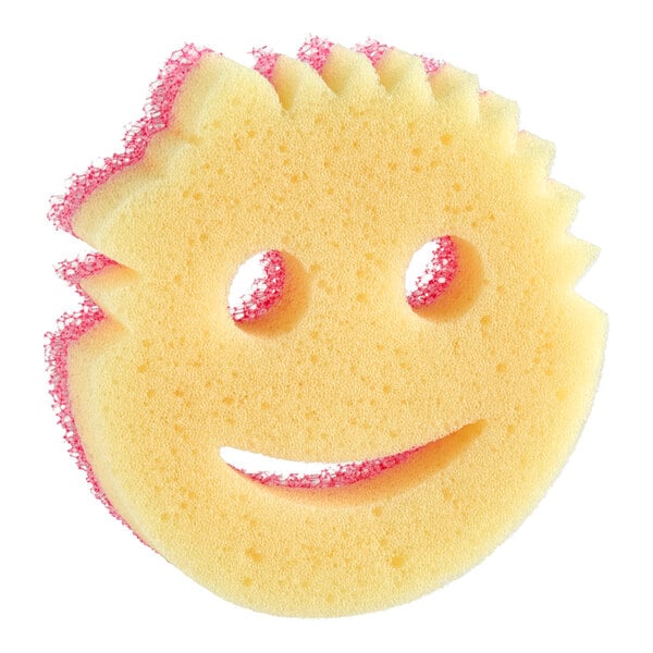 A round yellow sponge with a smiley face design and pink scrubbing edges.
