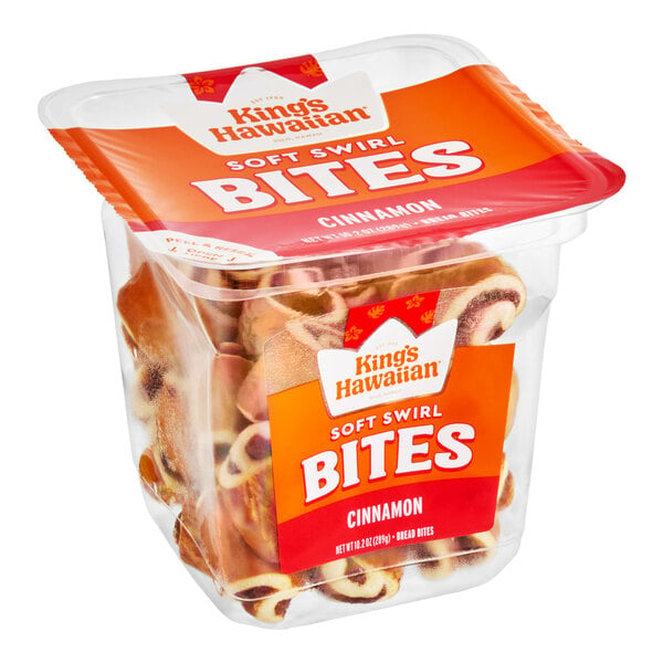 A clear plastic container filled with cinnamon swirl bread bites, labeled 'King's Hawaiian Soft Swirl Bites Cinnamon.'