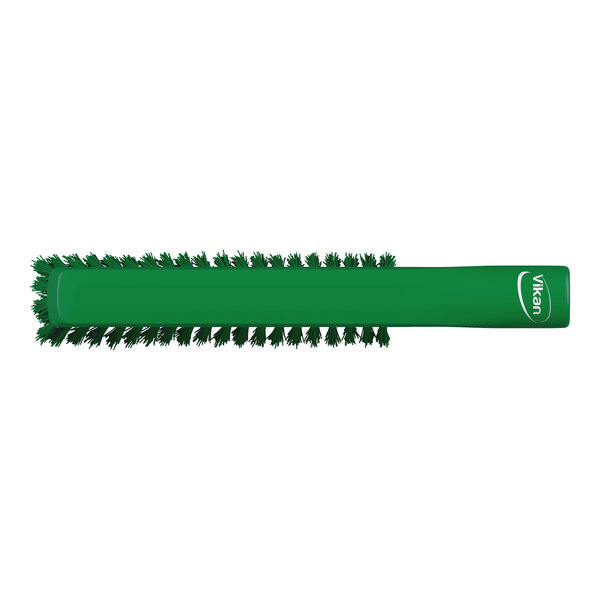 A green cylindrical brush with bristles arranged around the entire surface and a handle on one end.