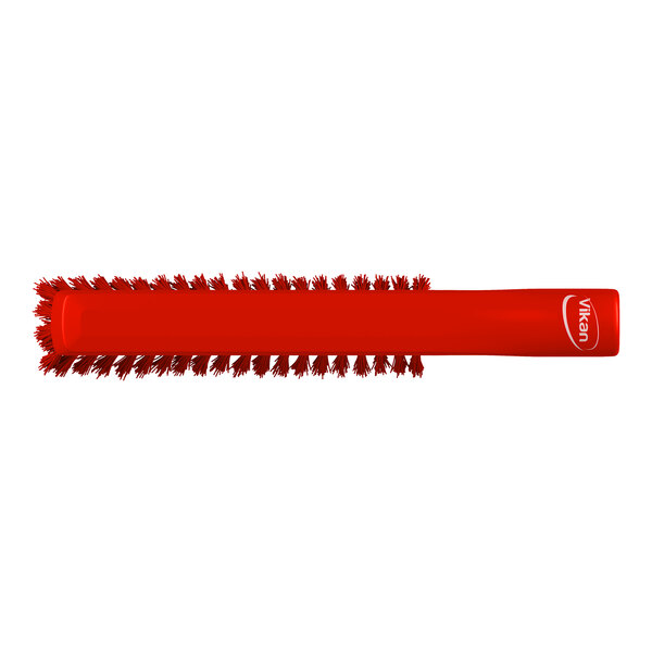 A red cylindrical brush with bristles arranged around the entire length and a handle on one end.