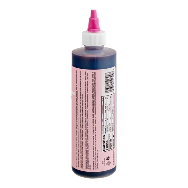 A plastic squeeze bottle with a pink label and a pink-tipped nozzle cap, containing a dark liquid inside.