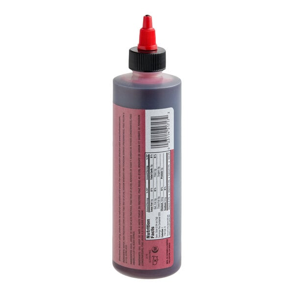 A plastic squeeze bottle with a red liquid inside, featuring a red nozzle cap and a label with nutritional information and a barcode.