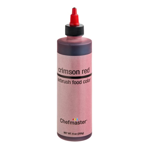 A bottle of crimson red airbrush food color with a red nozzle and labeled "Chefmaster" on the front.