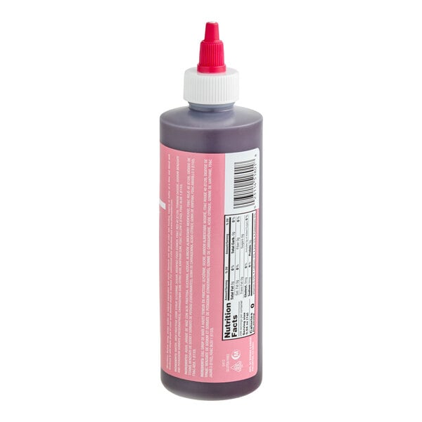 A plastic squeeze bottle with a pink label, white cap, and red nozzle, containing a dark liquid and displaying nutrition facts and a barcode.
