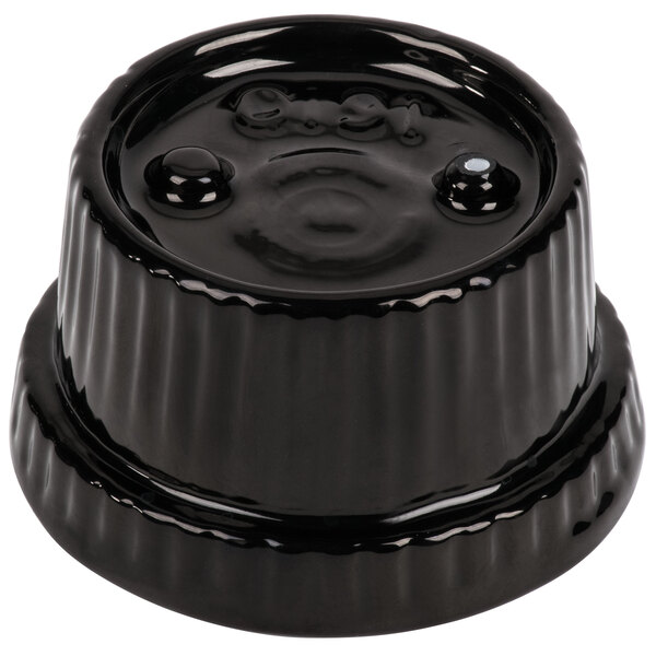 A black cast aluminum souffle bowl with ridges on the top.