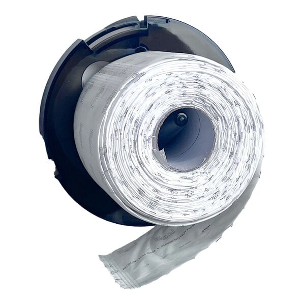 A black circular dispenser holding a roll of clear plastic bags or pads, with one section unrolled and hanging down.