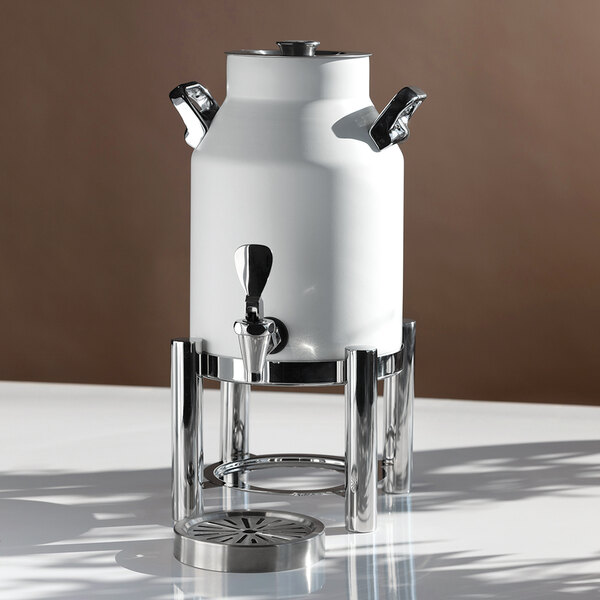 A white, stainless steel vacuum-insulated urn with a spigot, two side handles, and a metal stand, designed for serving beverages.