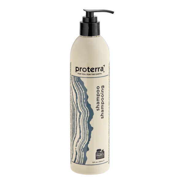 A tall, cylindrical bottle with a pump dispenser, featuring a cream-colored body, blue wavy design, and labeled as shampoo.