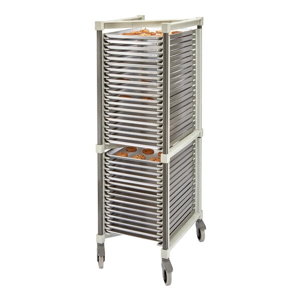 A tall, wheeled rack holding multiple metal trays, some with baked goods visible on them.