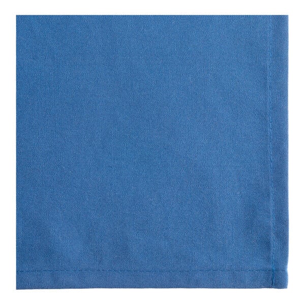 A close-up view of a blue fabric napkin with visible stitching along the edges.