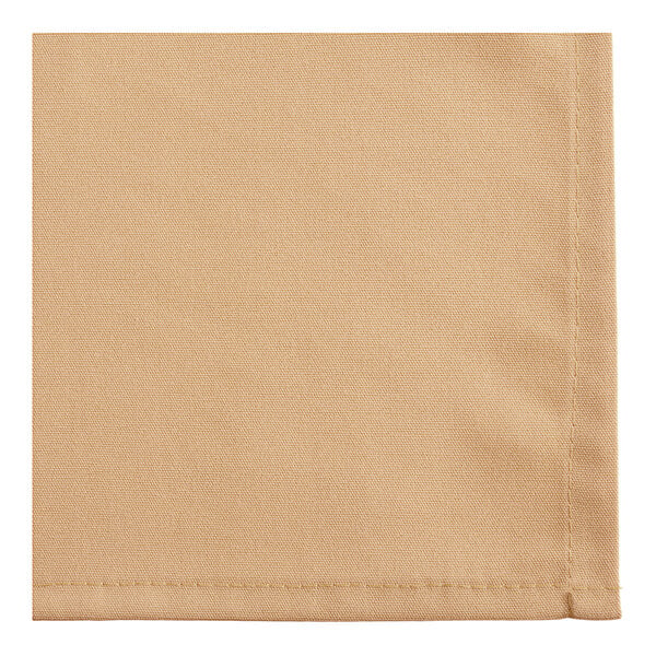 A close-up view of a beige fabric napkin with visible stitching along the edge.