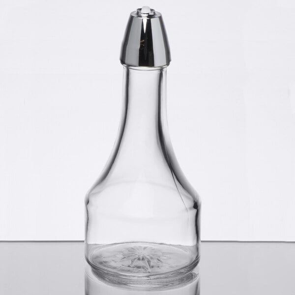 A clear glass bottle with a wide base and a chrome-colored plastic cap.