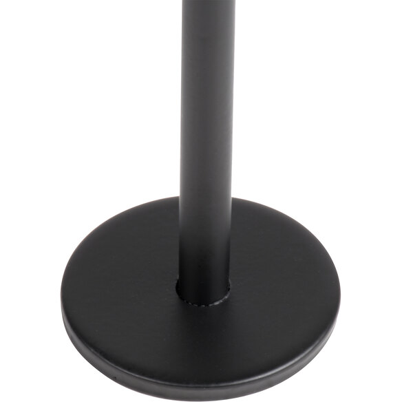 A close-up view of a black, round flat base with a vertical rod attached at the center.