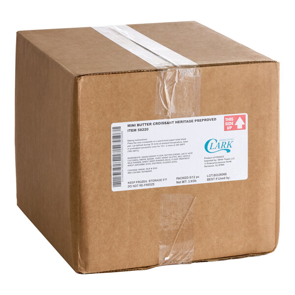 A sealed brown cardboard box with a white product label and clear tape, labeled for mini butter croissants.