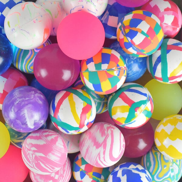 A pile of colorful, assorted bouncy balls with various patterns and solid colors.