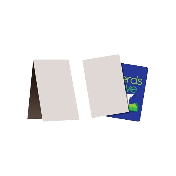 Two blank, rectangular chipboard sleeves are shown, one standing open and the other partially covering a blue card with green and white text.