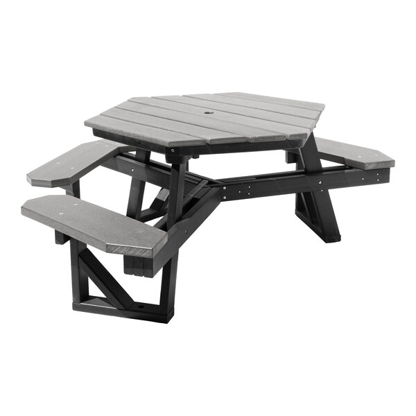 A gray, hexagonal picnic table with attached benches and a central hole, made from slatted material.