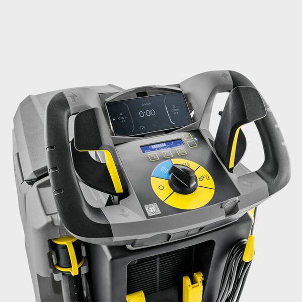 A close-up view of the control panel and handles of a large industrial cleaning machine, featuring a digital display, control buttons, and a rotary switch with yellow and black accents.