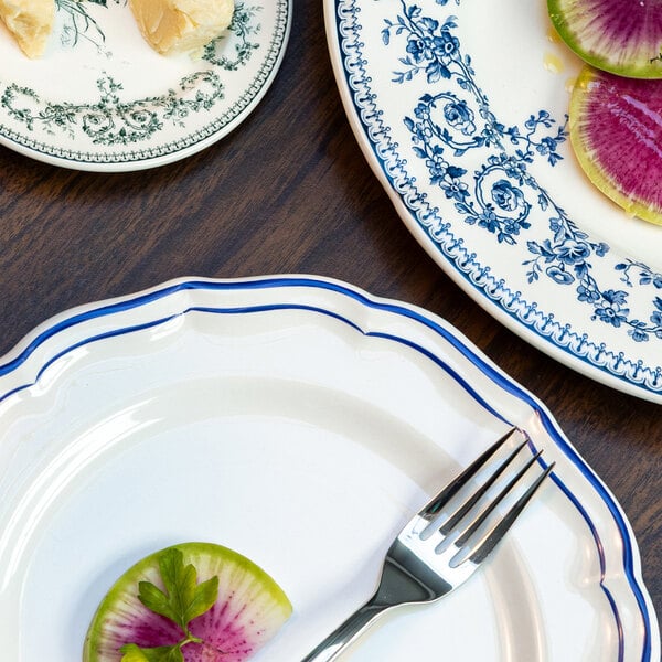 A partial view of three decorative plates with blue patterns, one holding a fork and a slice of radish, on a wooden surface.