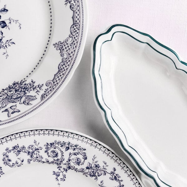 Three ceramic plates are shown, two with intricate blue floral patterns and one with a scalloped edge and green border on a white background.
