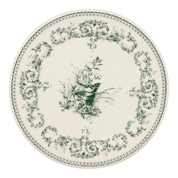 A round white plate with green floral patterns along the border and a central illustration of a bird perched among branches.