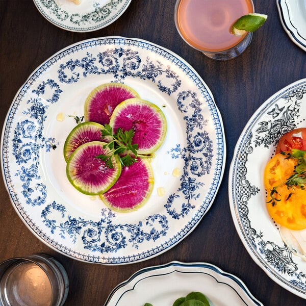 A decorative white plate with blue floral patterns, holding several slices of vibrant watermelon radish garnished with greens.