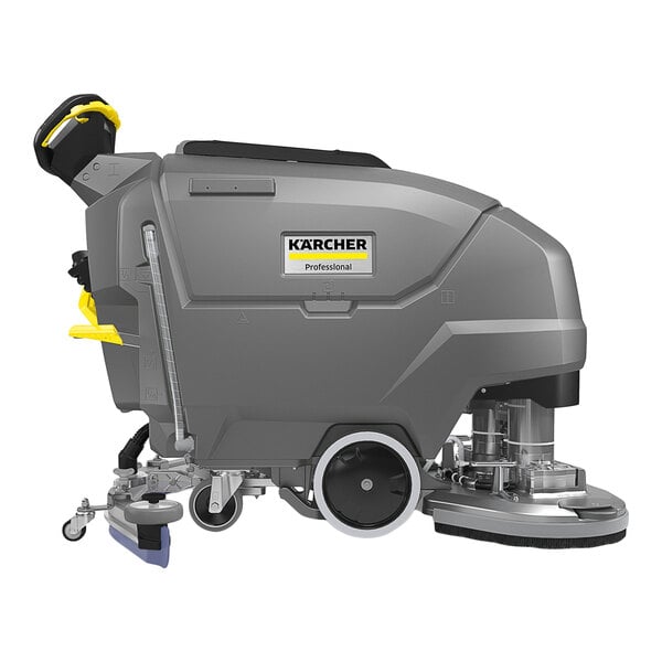 A large, gray, industrial floor scrubber with wheels, a handle, and visible cleaning components.