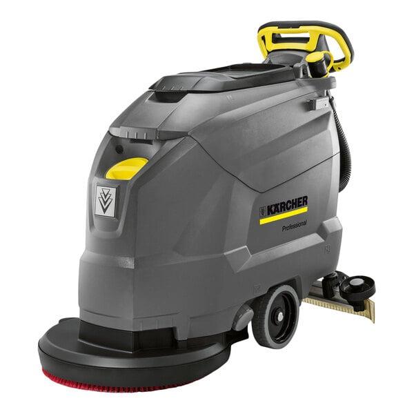 A large, gray and yellow walk-behind floor scrubber with wheels, a handle, and visible cleaning components.