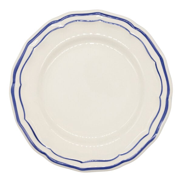 A white scalloped plate with two blue lines along the rim.