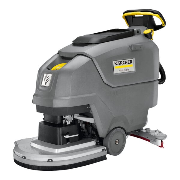 A large, gray walk-behind floor scrubber with a handle, wheels, and visible control panel, labeled with the Kärcher brand.