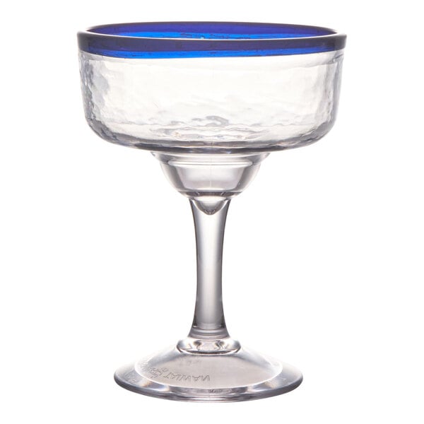 A clear margarita glass with a textured bowl and a blue rim, standing on a short stem and wide base.