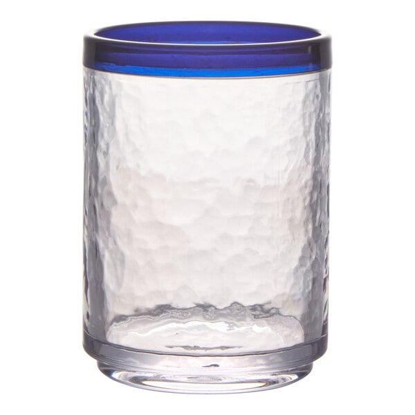 A clear, textured drinking glass with a thick blue rim at the top.